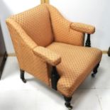 Antique low orange upholstered armchair with castors. 73cm wide x 75cm high x 80cm deep.