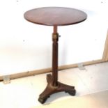 Regency Mahogany circular adjustable height table, on reeded column support, on tripod base ending