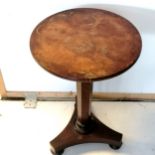 An Antique walnut pedestal, circular top occasional table on bun feet fitted with castors, the top