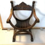 A carved oak Savonarola chair, 60 cm in length, 85 cm in height, 40 cm in depth. In good used