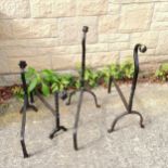 Pair of Forged Fire dogs 67 cm high x 48 cm length t/w similar but smaller 41 cm high x 53 cm