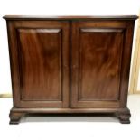 Antique mahogany 2 door cupboard, with single shelf, heavy brass handles to the sides, on shaped