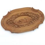 Carved oval plaque depicting lions. 22 x 13cm.