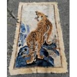 Tibetan/Chinese sheepskin rug in cream depicting a tiger on a hill. Measures 159 x 88cm. Badly