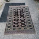 Pink rug with black diamond pattern. 164 x 130cm.