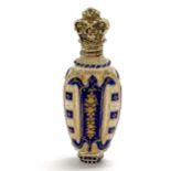 Good quality antique overlaid glass bodied scent bottle with raised gilt decoration & with silver