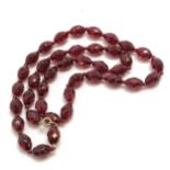 An antique strand of facet cut garnet beads 54cm long