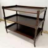 Antique mahogany 3 tier trolley, with turned column supports, terminating on brass castors, 66 cm