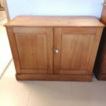 Antique pine 2 door Cupboard, with panelled doors, revealing fitted shelf, on platform base. 122