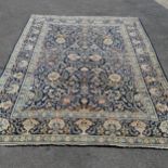 Large Persian Kashan carpet in blue depicting flowers in vases. Measuring 345 x 260cm. In good