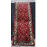 Red grounded Persian runner rug. 195 x 65cm.