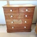 Antique pine chest of 2 short and 3 long graduated drawers, with white ceramic knobs, on platform