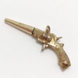 Novelty fob watch winder in the form of a pistol gun in gilt metal - 5cm and has slight dents to