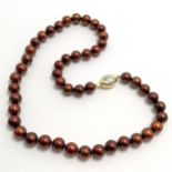 Strand of chocolate coloured pearls with a 9ct marked gold clasp - 44cm long