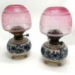 Antique pair of pottery lamp bases with floral decoration with cranberry acid etched shades &