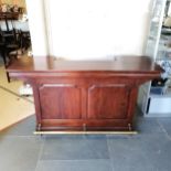 Mahogany panel fronted bar, fitted with stainless steel basin, and a brass foot rail, 63 cm wide,