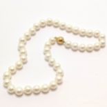 String of cultured pearls (43cm long & pearls approx 10mm diameter) with a 9ct marked gold ball