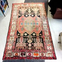 Hand woven Turkish wool rug with orange ground - 130cm x 215cm in used condition with no obvious