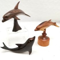 Rosewood carved dolphin on naturalistic base, 20 cm high, 27 cm length, t/w 2 similar.