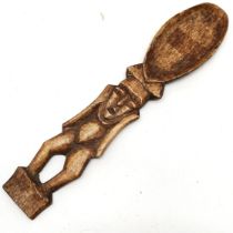 Carved bone spoon in the form of a triabal figure, 20 cm length.