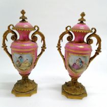 Pair of antique French pink grounded porcelain urns with gilt ormolu detail with hand decorated