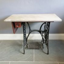 Singer cast iron treadle sewing machine base fitted with grey piece of marble, 100 cm wide, 55 cm