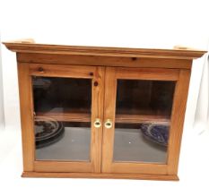 Pine 2 door glazed wall cabinet, 74 cm wide, 31 cm deep, 58 cm high.in good used condition.