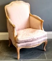 French style salon chair, limed oak frame with carved decoration, upholstered in a pink damask, in