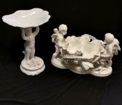 Antique white porcelain table centre of cherubs surrounding large flower head, some losses and