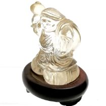Oriental carved rock crystal figure of a man carrying a sack on a wooden base - total height 8.5cm