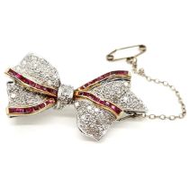 Ruby and diamond set bow brooch in 18ct white gold. With 33 yellow gold channel set baguette