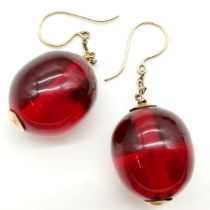 Pair of red amber bead earrings with unmarked gold mounts bead approx 2.5cm across ~ 6cm drop & 15.