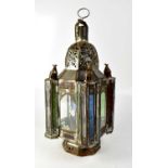 A large ornate Moroccan metal and glass candleholder with pierced domed top and four glass columns