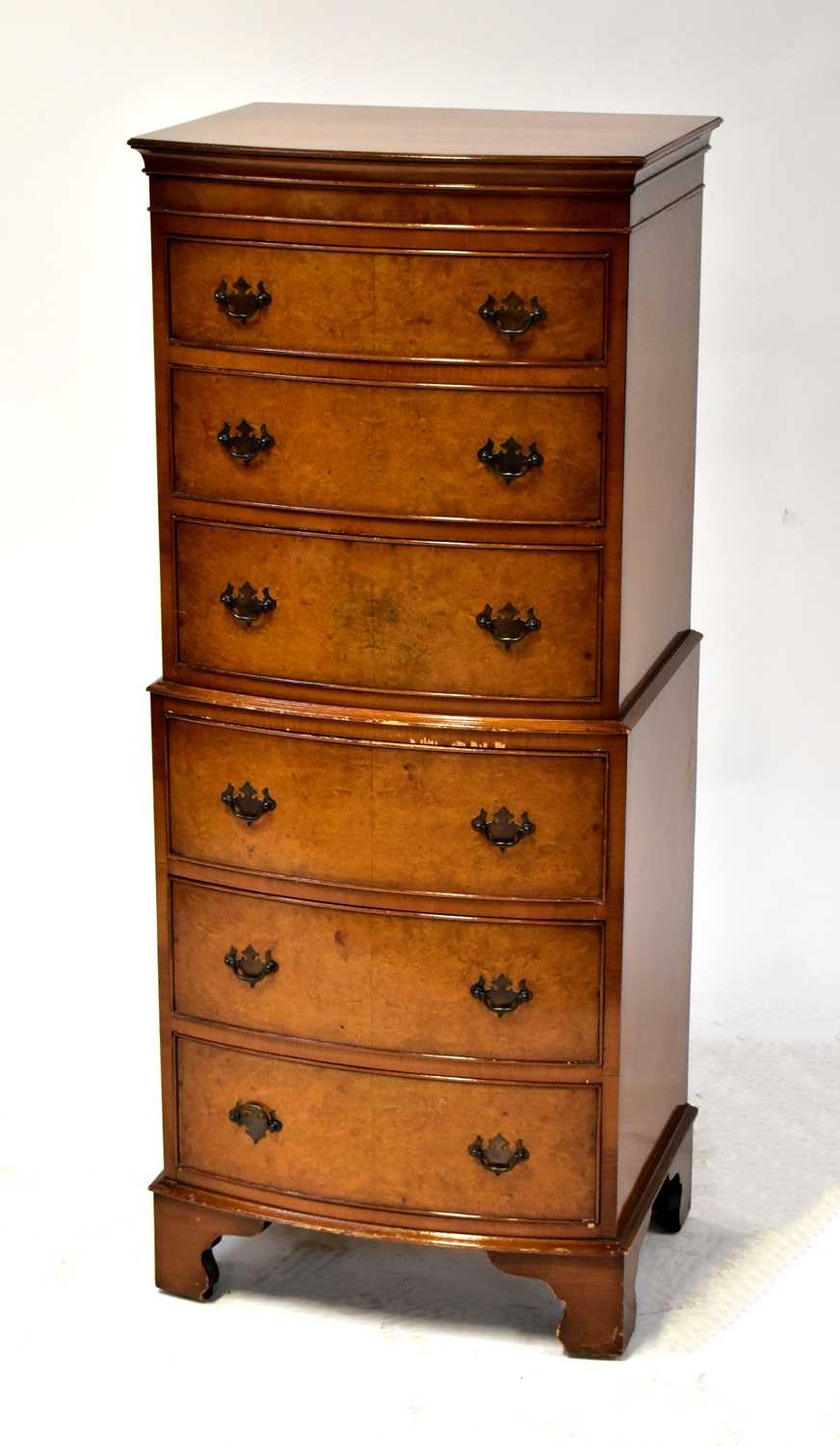 A reproduction walnut veneered small chest-on-chest, 131 x 54 x 42cm.131 x 54 x 42cm