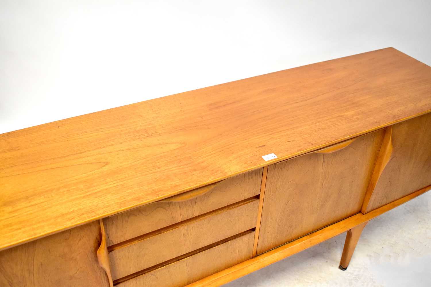 A 1960s teak sideboard with central fall front and three drawers, flanked by a pair of cupboard - Image 2 of 2