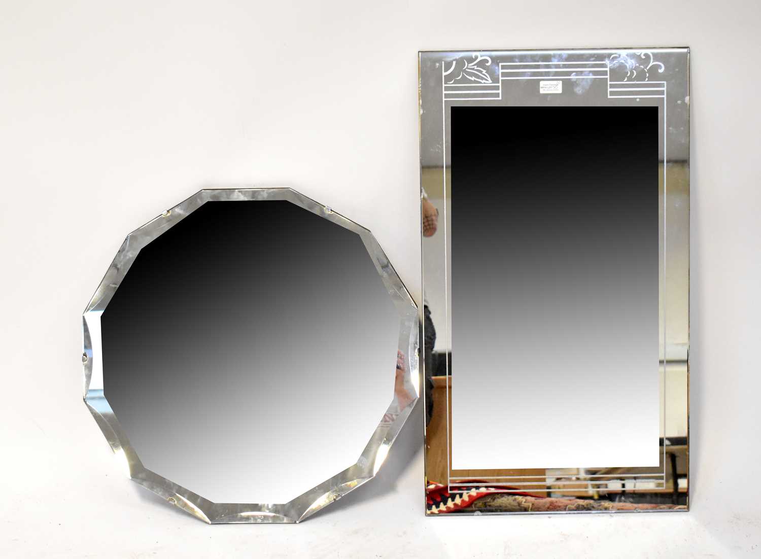 A 1940s shaped peach glass wall mirror, diameter 59cm, also a rectangular mirror plate with simple