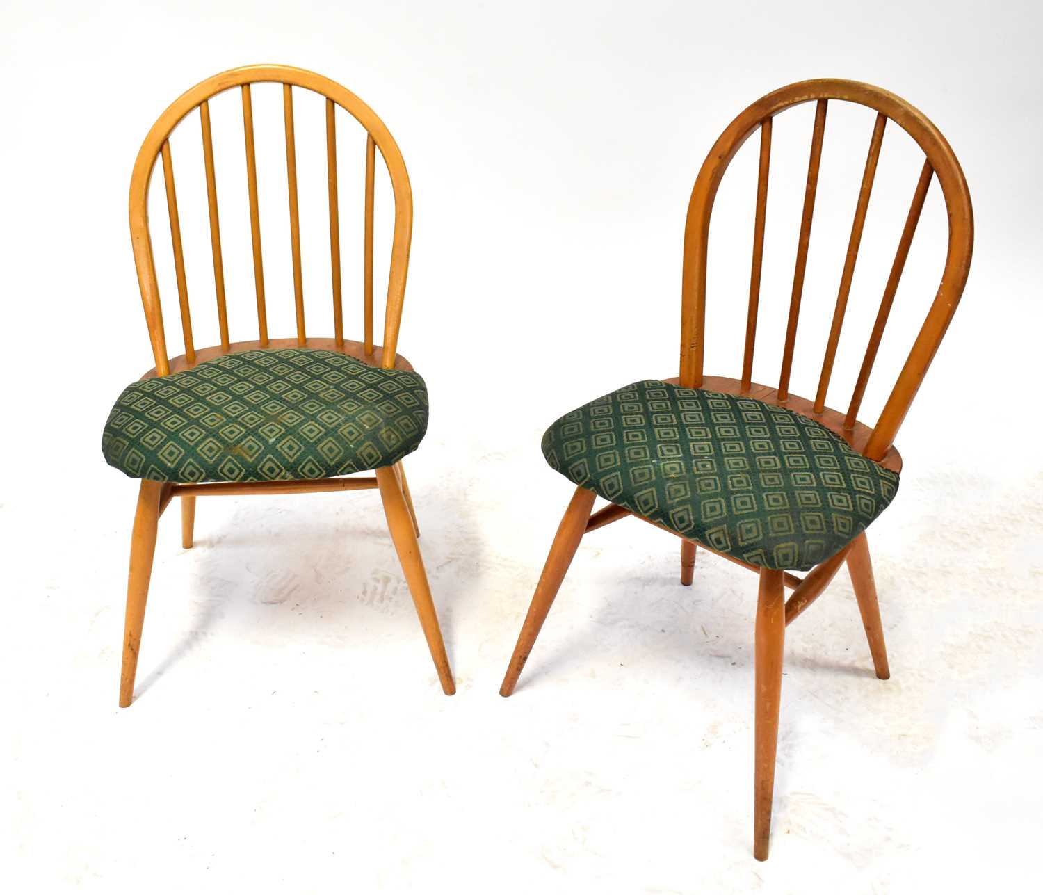 ERCOL; a set of four stick back Windsor chairs with padded seats (4).Qty: 4