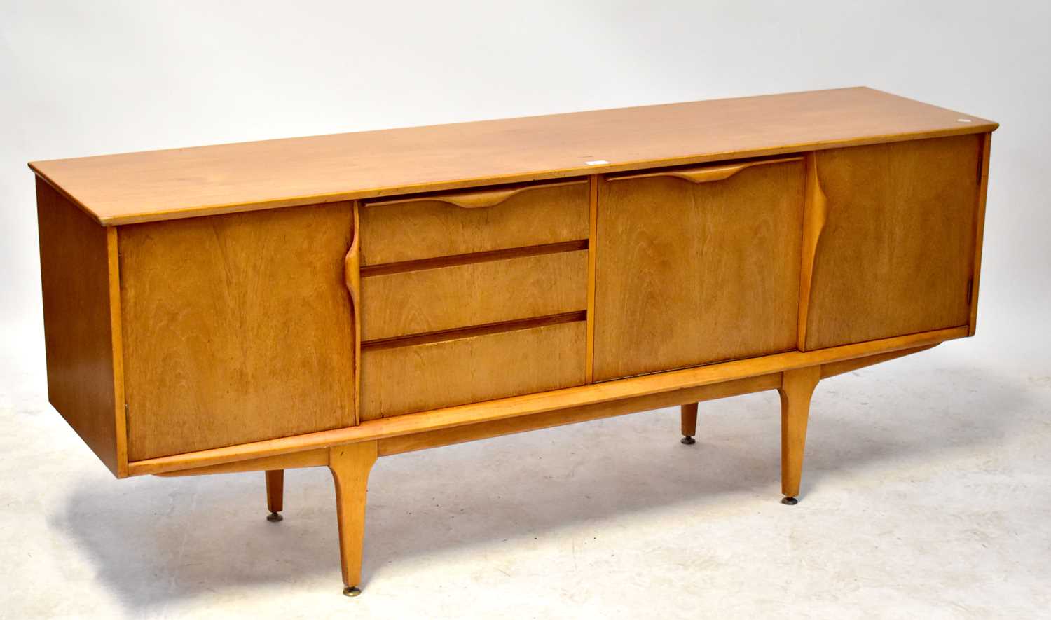 A 1960s teak sideboard with central fall front and three drawers, flanked by a pair of cupboard