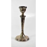 A George V hallmarked silver column candlestick to stepped circular base, maker's mark rubbed,