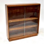 A teak mahogany glazed bookcase with pair of sliding doors enclosing three adjustable shelves,