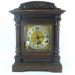 An early 20th century oak cased chiming mantel clock with square brass face and silvered chapter
