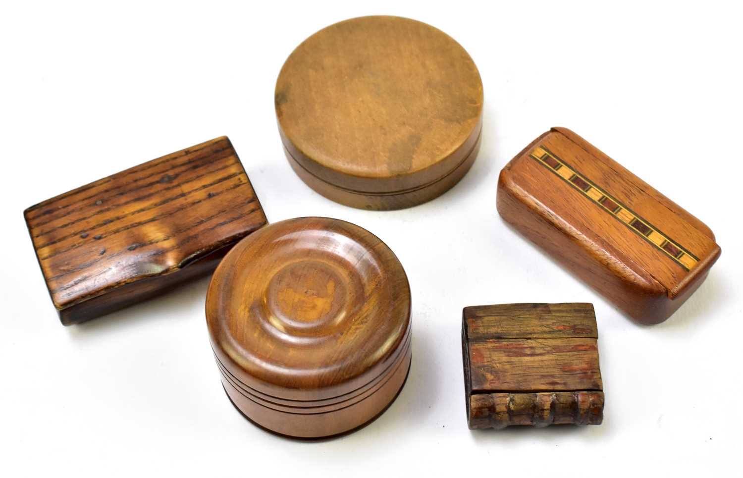 Five early 20th century and later treen snuff boxes to include a circular example, diameter 6cm, a