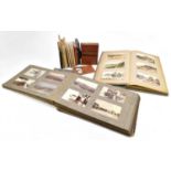 An early 20th century photograph album, a sparcely filled postcard album with topographical cards,