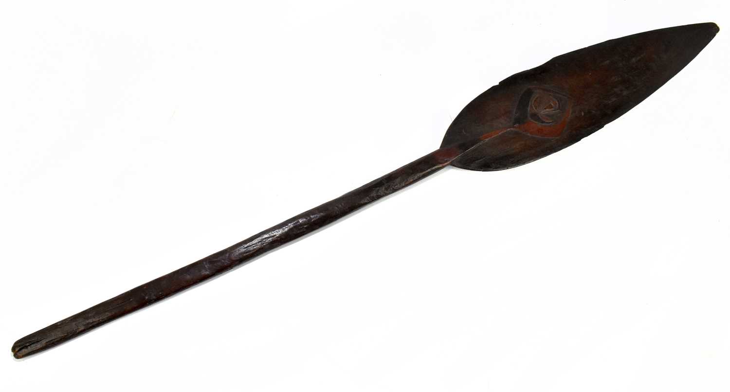 A late 19th/early 20th century hardwood tribal paddle with the detail of a stylised face to one side