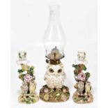 A late 19th century Continental porcelain figural oil lamp modelled as an owl perching on floral