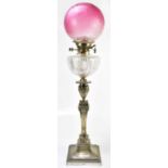 A 19th century silver plated oil lamp with cranberry and frosted glass shade above the cut glass