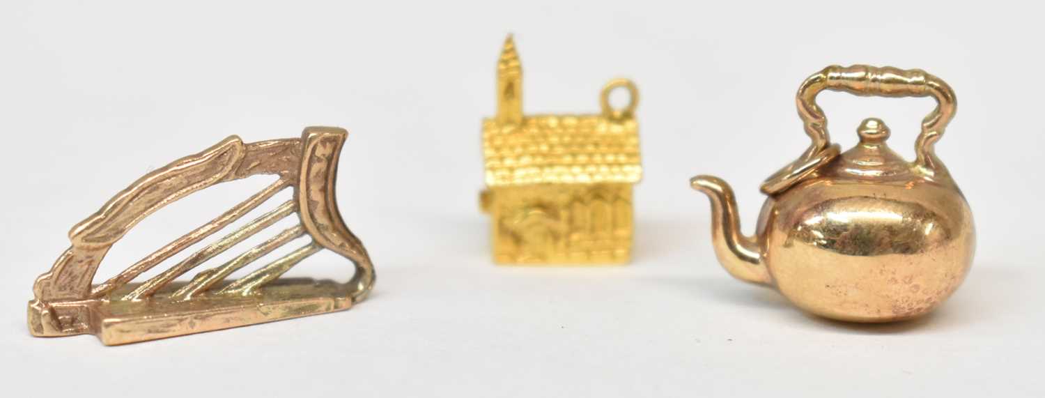 Three 9ct yellow gold charms modelled as a kettle, harp and church, combined approx 6.3g