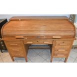 An early 20th century oak seven drawer roll top desk, width 152cm.