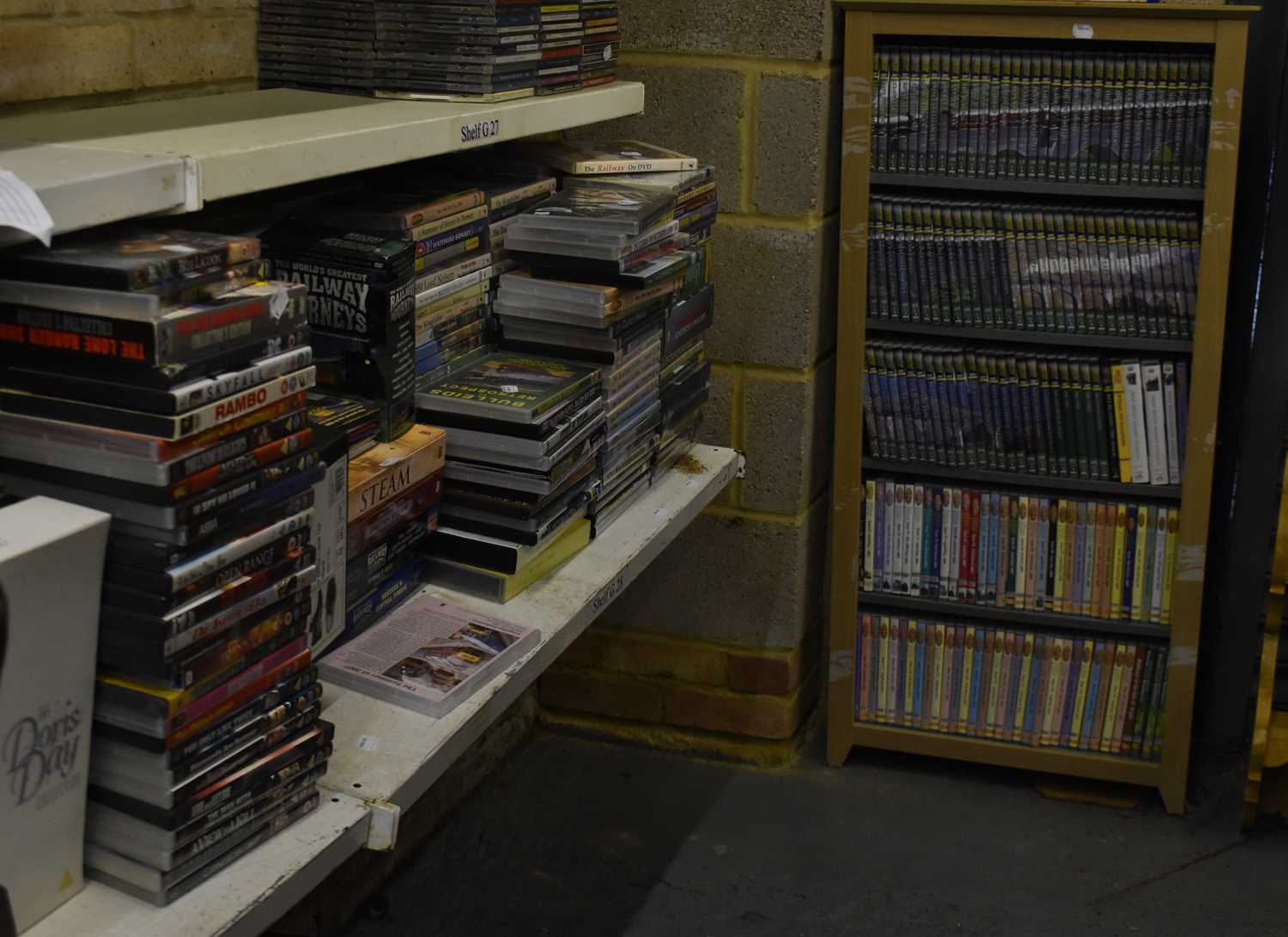 A quantity of railway related DVDs contained in a bookshelf and numerous loose examples, and various