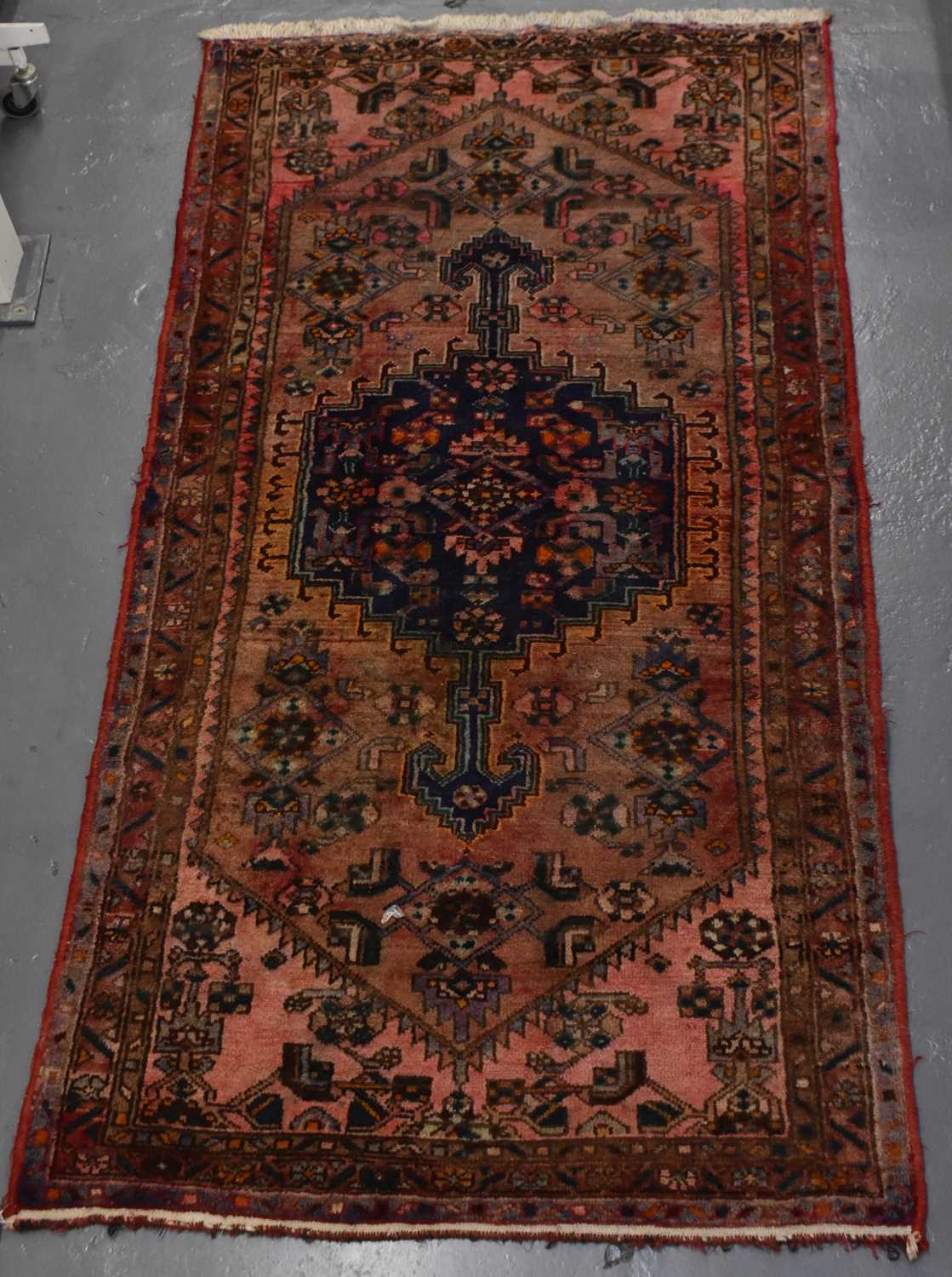 A hand knotted woollen red/blue ground rug, 215 x 107cm.